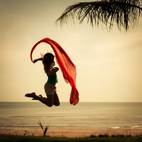 Menina feliz pulando na praia — Fotografia de Stock