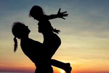 Anne ve kızı sahilde oynuyorlar.