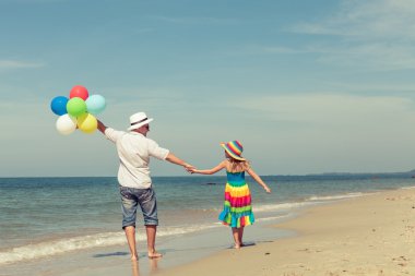 Baba ve kızı da plajda oynarken balonlar ile