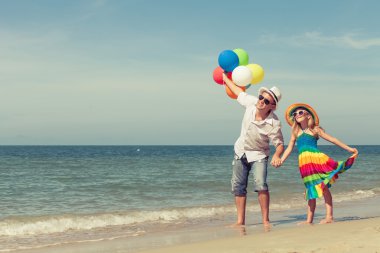 Baba ve kızı da plajda oynarken balonlar ile