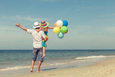 Baba ve kızı da plajda oynarken balonlar ile