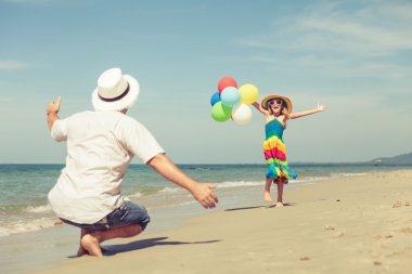 Baba ve kızı da plajda oynarken balonlar ile