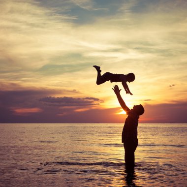 Baba ve oğul sahilde oynuyorlar.