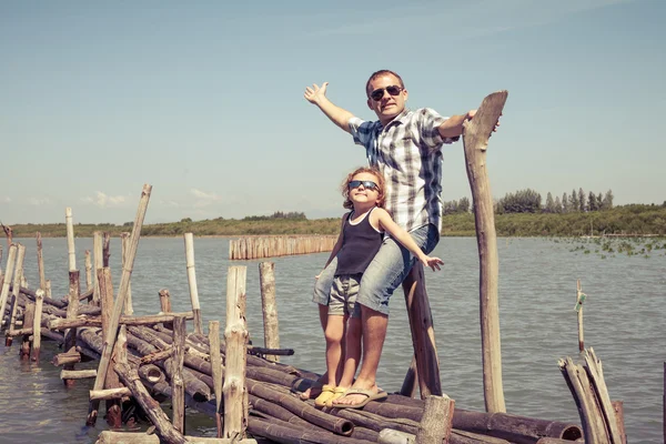 Pai e filho descansando na ponte no mar na hora do dia . — Fotografia de Stock