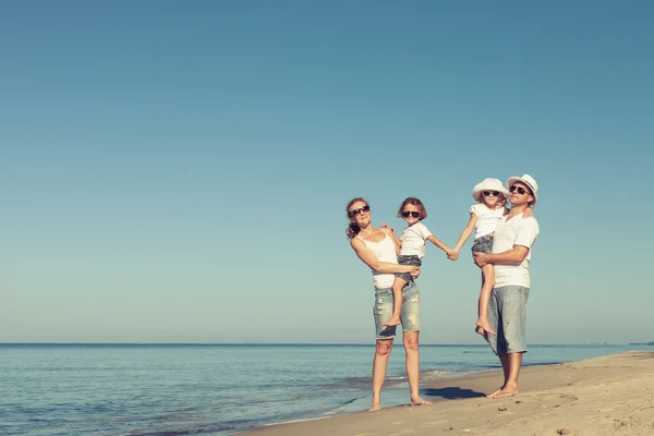 Familia feliz de pie en la playa durante el día . —  Fotos de Stock