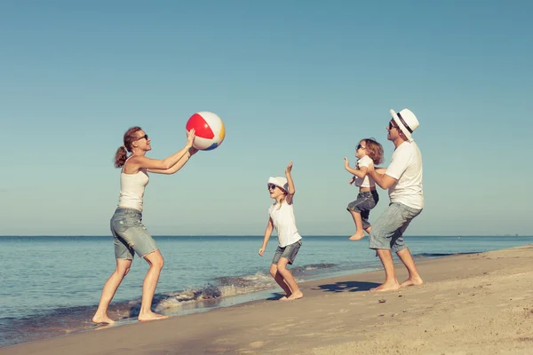 Szczęśliwa rodzina gra na plaży w czasie dnia. — Zdjęcie stockowe