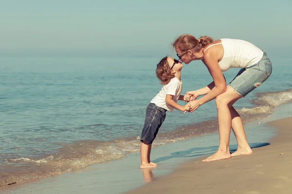 Mor och son spelar på stranden på dagarna. — Stockfoto