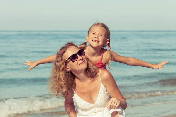 Anne ve kızı kumsalda gün anda oynamak. — Stok fotoğraf