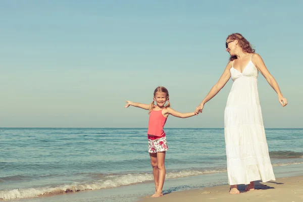 Madre e hija jugando en la playa durante el día . — Foto de Stock