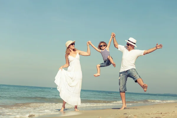 Família feliz brincando na praia na hora do dia . — Fotografia de Stock