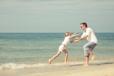 Baba ve kızı kumsalda oynarken.