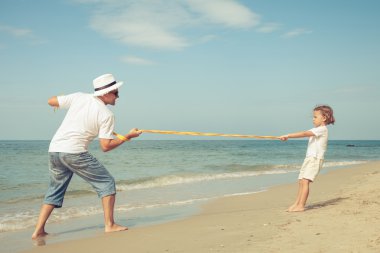 Baba ve oğul plaj gün anda oynamak.