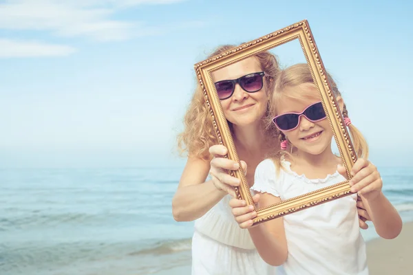 Madre e figlia che giocano sulla spiaggia durante il giorno . — Foto Stock