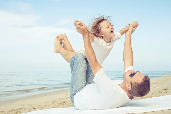 Apa és fia játszik a tengerparton nap idején. — Stock Fotó