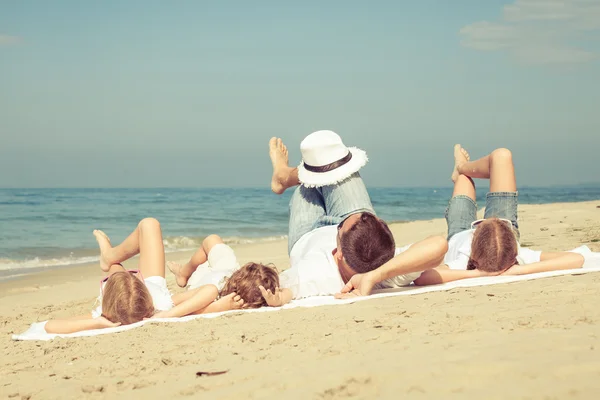 Glückliche Familie, die tagsüber am Strand spielt. — Stockfoto