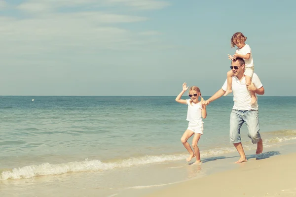 Glückliche Familie, die tagsüber am Strand spielt. — Stockfoto