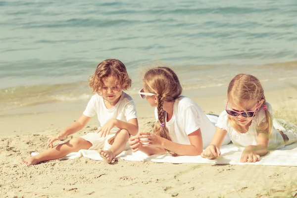 Dos hermanas y hermano jugando en la playa — Foto de Stock