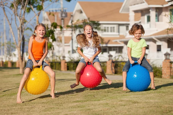 Enfants heureux jouant avec des boules gonflables sur la pelouse — Photo