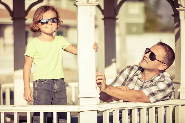 Vader en zoon spelen in de buurt van het huis op het moment van de dag. — Stockfoto