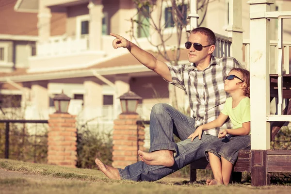 Padre e figlio che giocano vicino alla casa durante il giorno . — Foto Stock