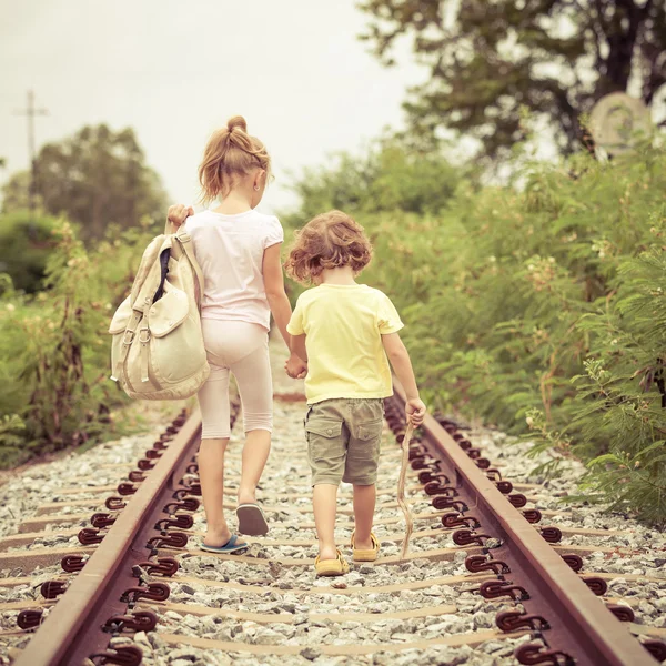 Due bambini piccoli con lo zaino in piedi sulla ferrovia — Foto Stock