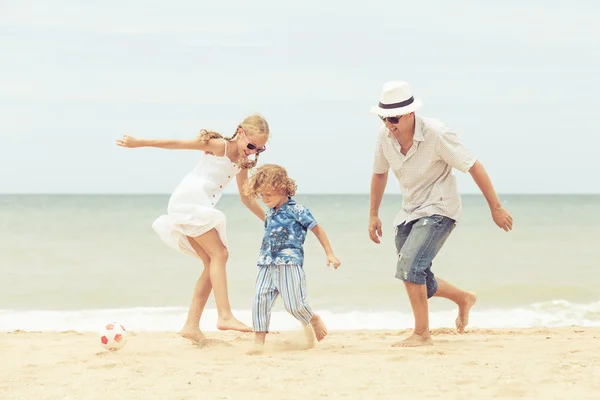 Padre e figli che giocano sulla spiaggia durante il giorno . — Foto Stock