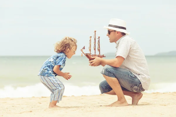 Padre e figlio che giocano sulla spiaggia durante il giorno . — Foto Stock
