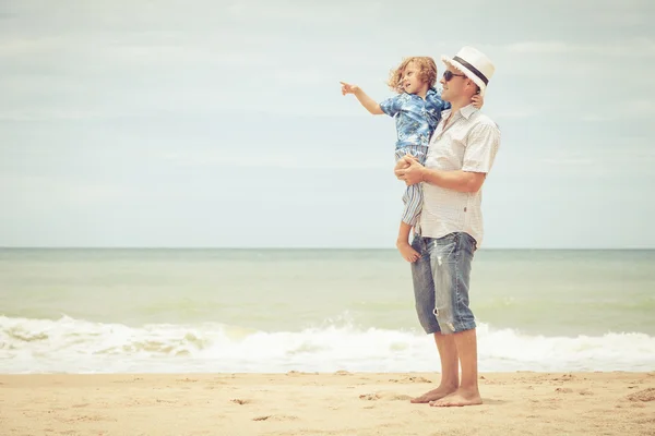 Padre e hijo jugando en la playa durante el día . — Foto de Stock