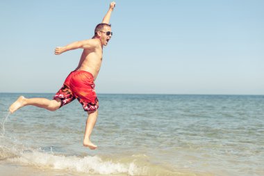 mutlu bir adam sahilde atlama