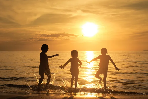 Niños felices jugando en la playa — Foto de Stock