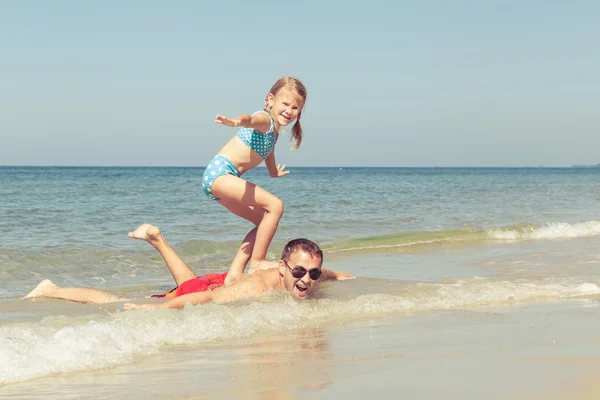 Father and daughter playing on the beach at the day time. — Stock Photo, Image