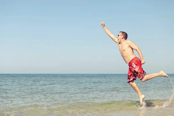 Uomo felice che salta sulla spiaggia — Foto Stock