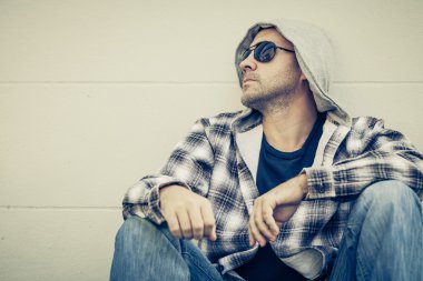 Güneş gözlüğü house yanında oturan üzgün bir adam portresi