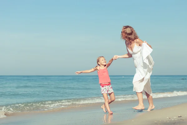 Mãe e filha brincando na praia no dia . — Fotografia de Stock