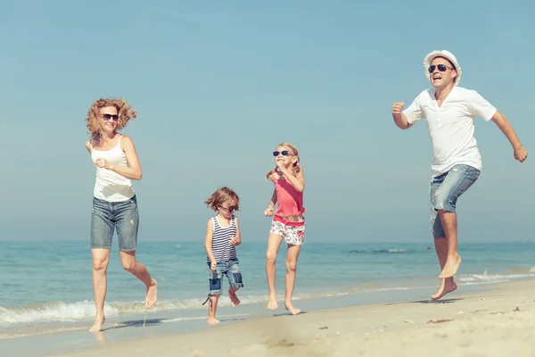 Glückliche Familie, die tagsüber am Strand spazieren geht. — Stockfoto