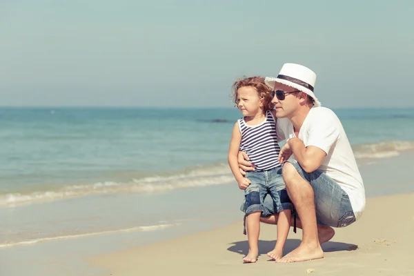 Padre e hijo jugando en la playa durante el día . — Foto de Stock