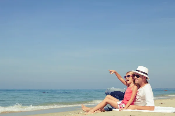 Vader en dochter spelen op het strand op het moment van de dag. — Stockfoto
