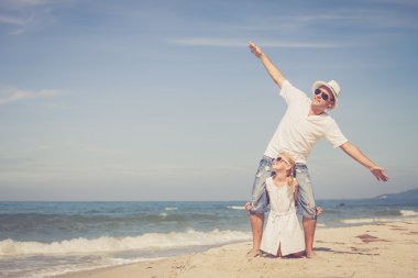 Baba ve kızı kumsalda gün anda oynamak.