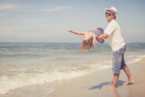 Padre e figlio che giocano sulla spiaggia durante il giorno . — Foto Stock