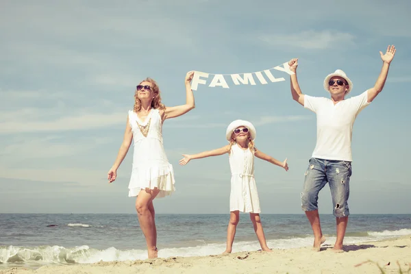 Familia feliz caminando por la playa durante el día . — Foto de Stock