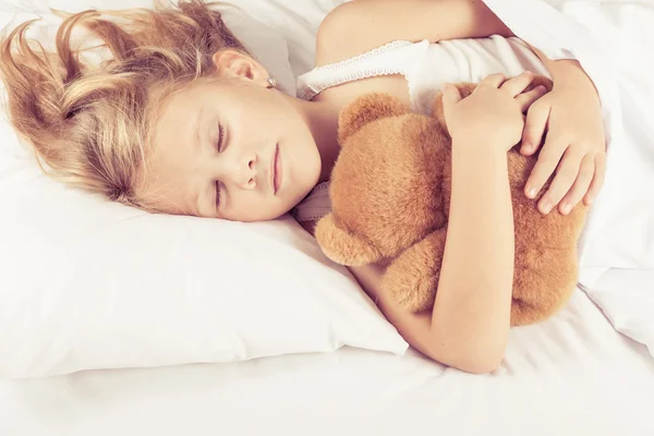 Милая маленькая девочка спит на кровати — стоковое фото