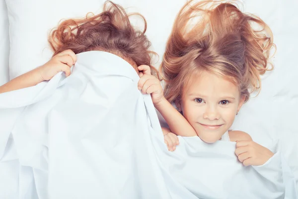 Precioso hermano y hermana acostados en la cama en casa . —  Fotos de Stock