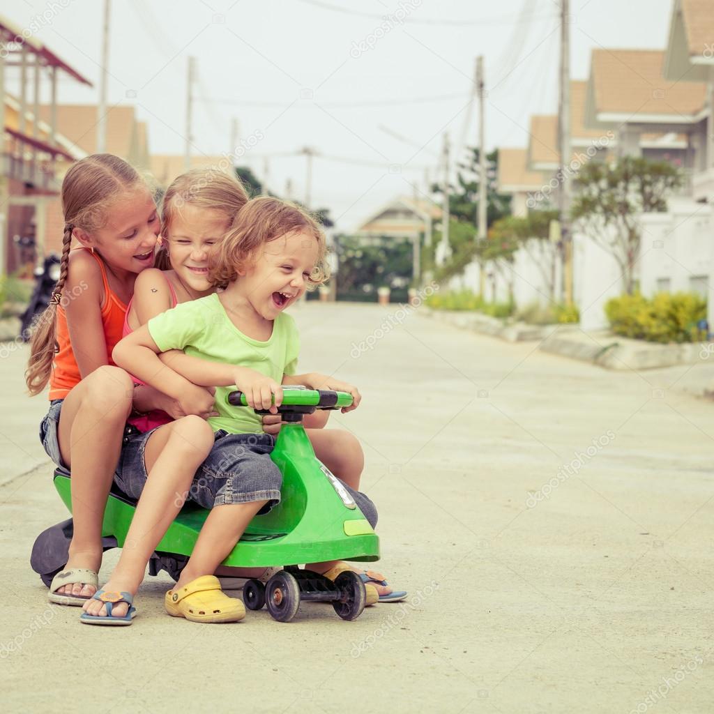 three happy children playing on the road