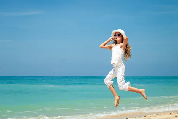 Teen girl  jumping on the beach at blue sea shore in summer vaca — Stock Photo, Image