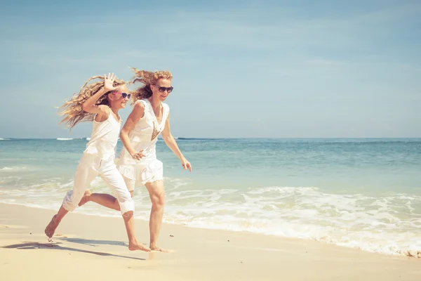 Glückliche Familie spielt tagsüber am Strand — Stockfoto