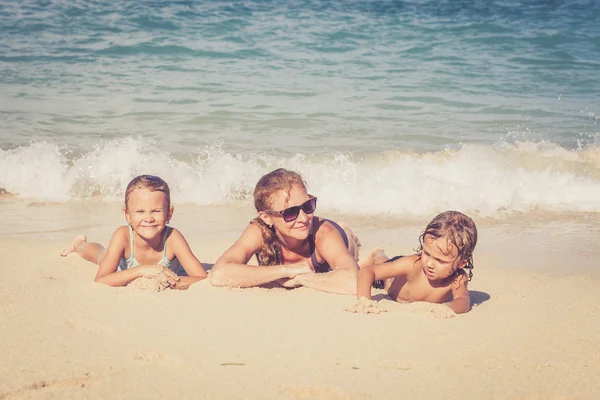 Familia feliz jugando en la playa durante el día — Foto de Stock