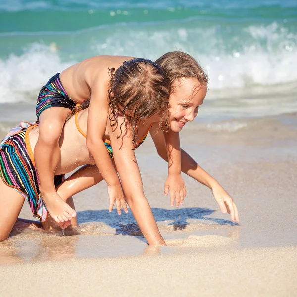 Glückliche Kinder, die tagsüber am Strand spielen — Stockfoto