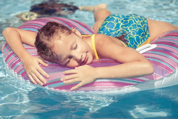 Bambina sdraiata sul cerchio di gomma gonfiabile nel nuoto — Foto Stock