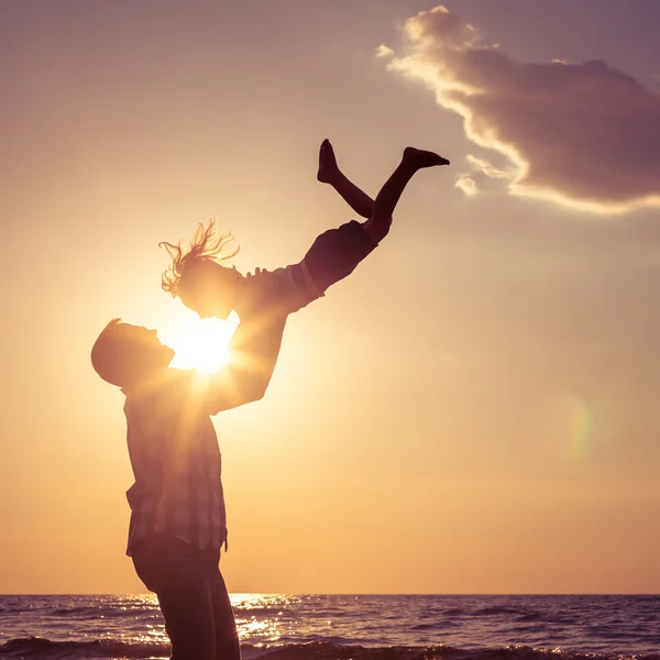 Father and son playing on the beach at the sunset time. — Zdjęcie stockowe