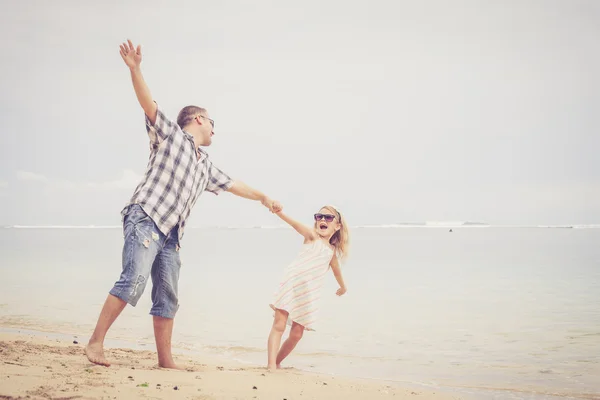 Vater und Tochter spielen tagsüber am Strand. — Stockfoto